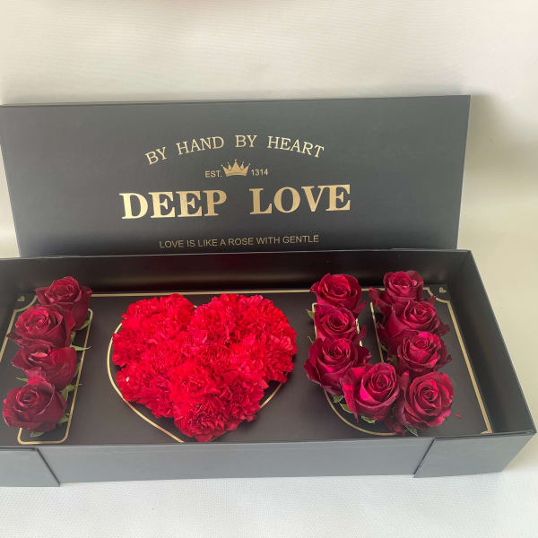 Boxed arrangement of red roses and a heart-shaped cluster of red carnations