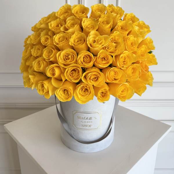 Bouquet of bright yellow roses in a silver hat box