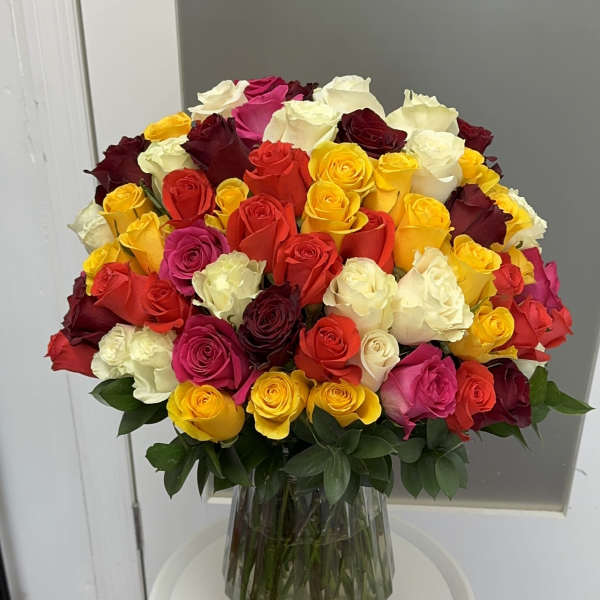 Large bouquet of multicolored roses in a clear glass vase