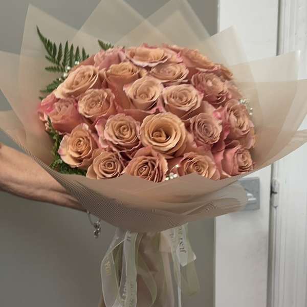 Bouquet of peach roses wrapped in translucent paper