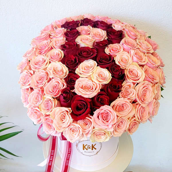Round bouquet of pink and red roses in a white hat box