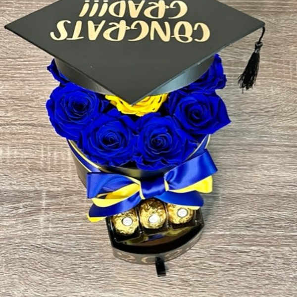 Blue roses arranged under a graduation cap with chocolates and ribbon