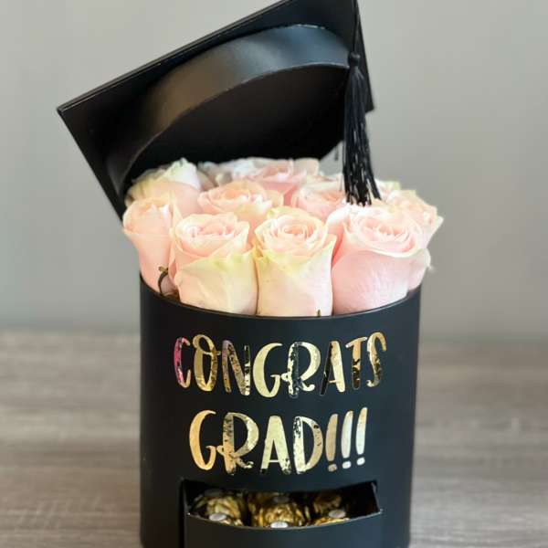 Pink roses in a black graduation box with a tassel