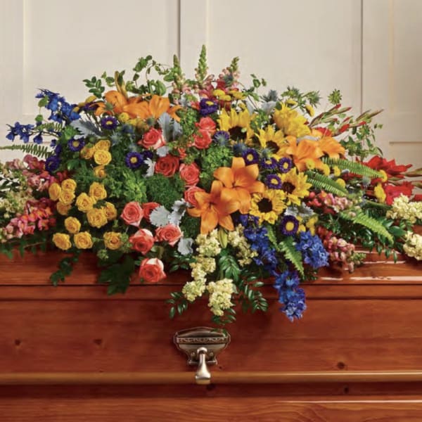 Colorful floral spray arranged on a wooden casket