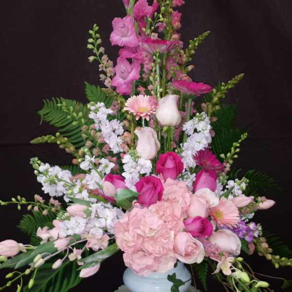 Tall pink and white floral arrangement in a white vase