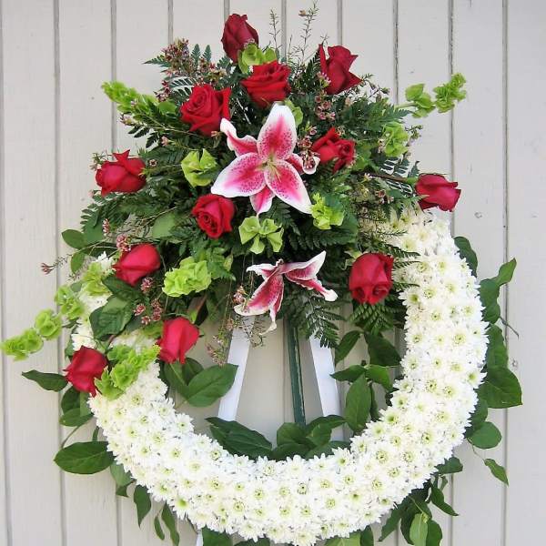 Standing floral wreath with red roses, pink lilies, and white chrysanthemums