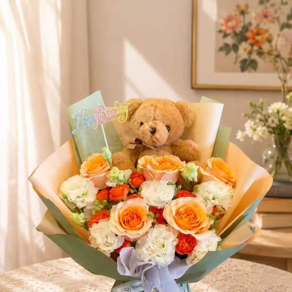 Bouquet of orange and white roses with a teddy bear and Happy Birthday topper