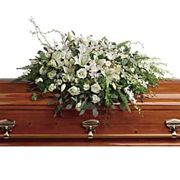 White floral casket spray with lilies and roses