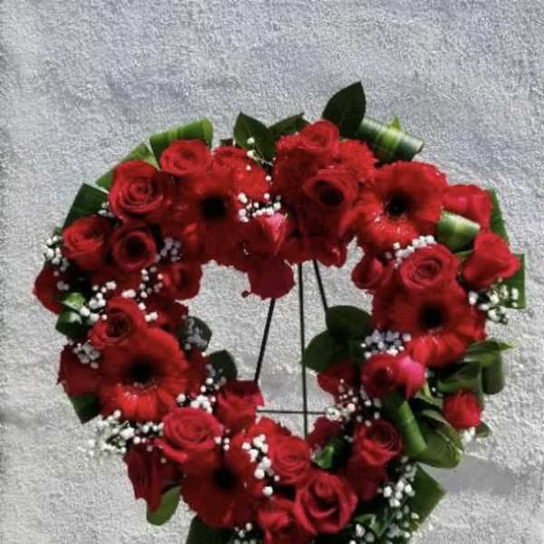 Heart-shaped red flower wreath on a stand