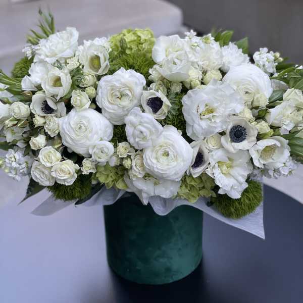White floral arrangement in a green cylindrical vase