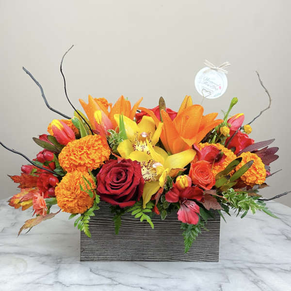 Bright mixed flower arrangement in a rectangular wooden box