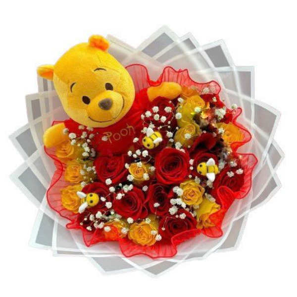 Bouquet of red and yellow roses with a Winnie the Pooh plush