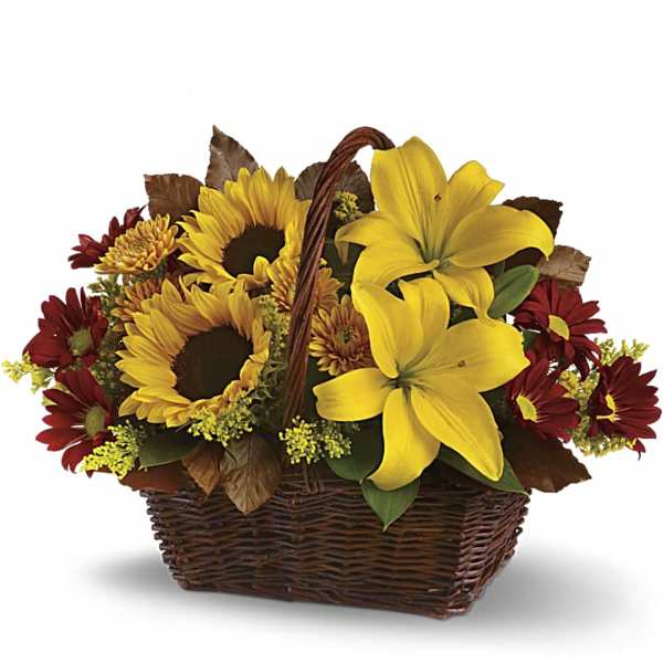 Basket arrangement with yellow lilies, sunflowers, and red daisies