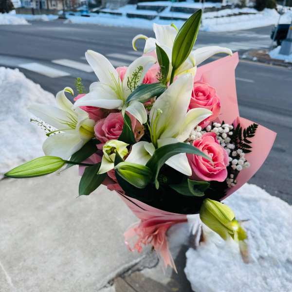 Pink rose and white lily bouquet wrapped in pink paper