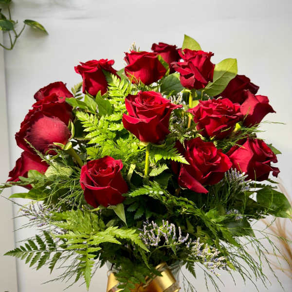Bouquet of red roses with greenery and a gold ribbon