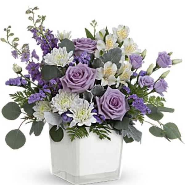 Lavender and white flower arrangement with roses and alstroemeria in a white cube vase