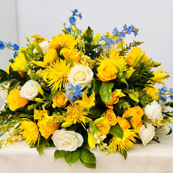 Yellow and white mixed flower arrangement with blue accents