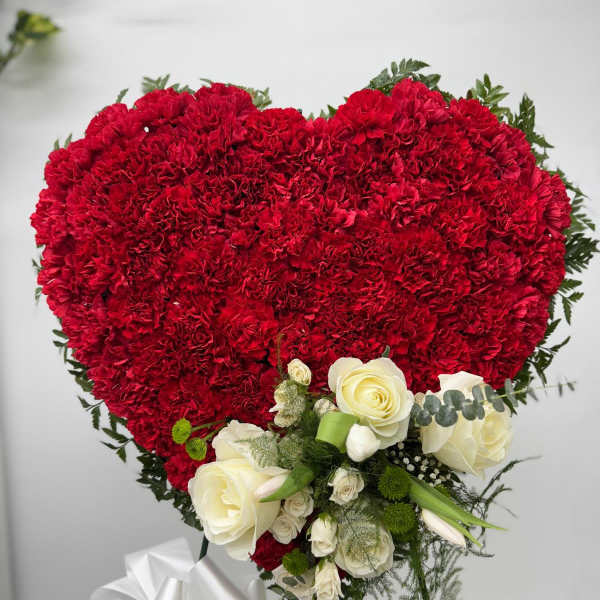 Heart-shaped red carnation arrangement with white roses and ribbon