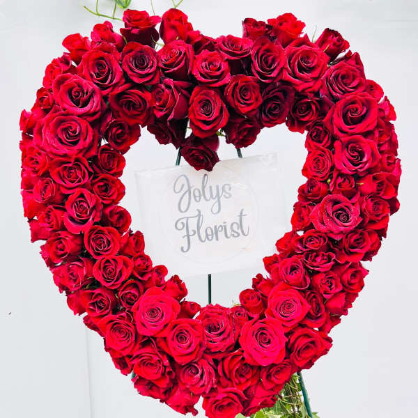 Heart-shaped arrangement of red roses on a stand