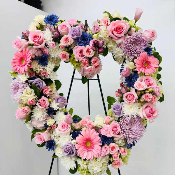 Heart-shaped floral wreath with pink, white, lavender, and blue blooms