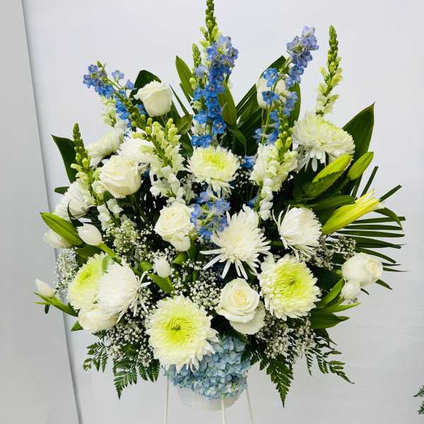 Large white and blue floral standing arrangement on a white stand