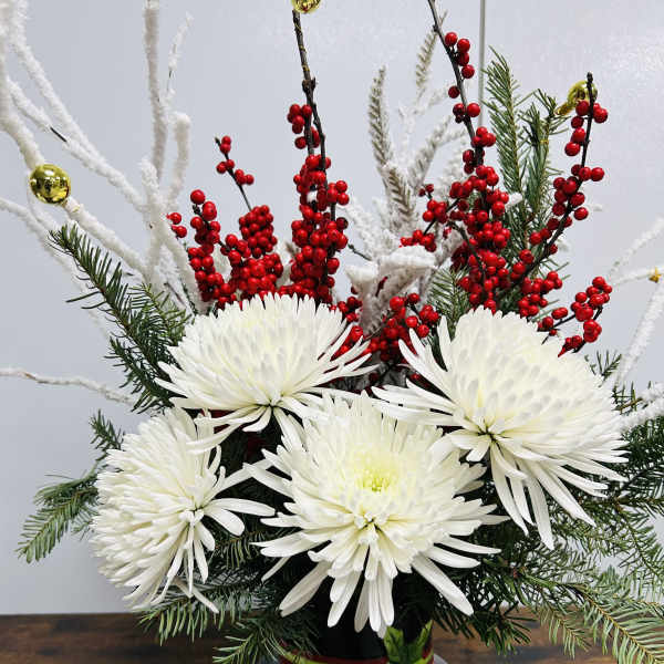 White chrysanthemum arrangement in a snowman vase with red berries