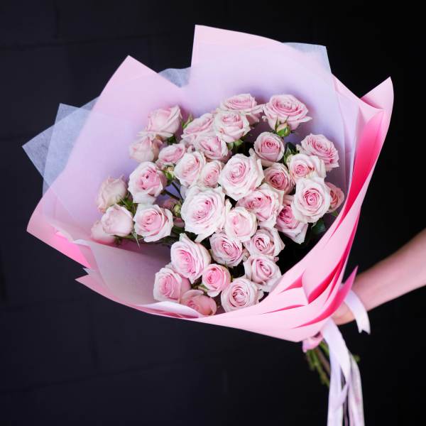 Bouquet of pale pink roses wrapped in pink paper