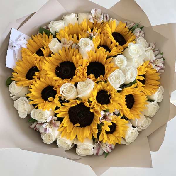 Bouquet of sunflowers, white roses, and pale pink alstroemeria in tan wrap