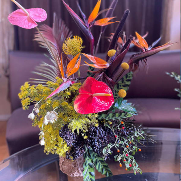 Tropical floral arrangement with pink anthuriums and orange bird-of-paradise