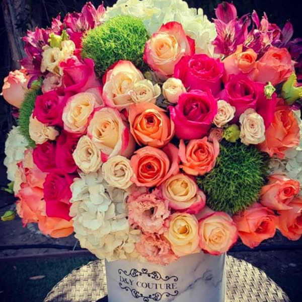 Mixed roses and hydrangeas in a white hatbox