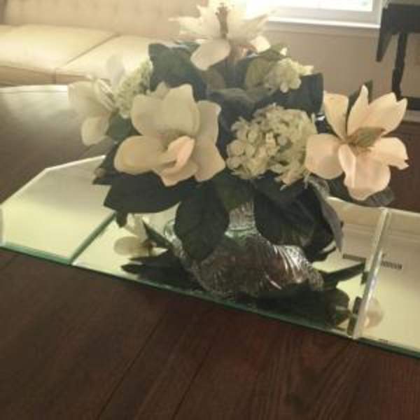 White floral arrangement in a mirrored vase on a mirrored tray