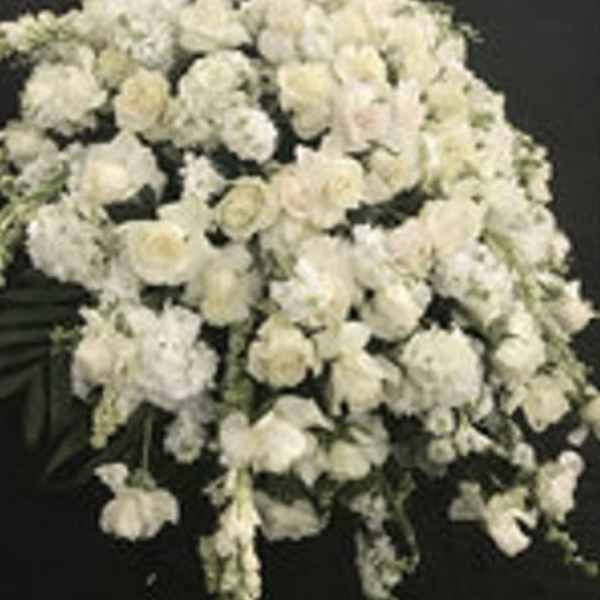 Large white floral spray with clustered blooms on a dark background