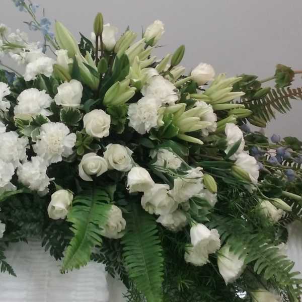Large white floral spray with lilies, roses, and carnations