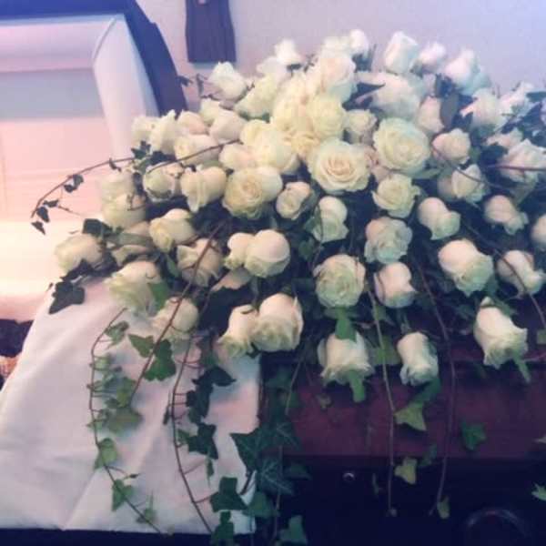 Large white rose casket spray with trailing ivy