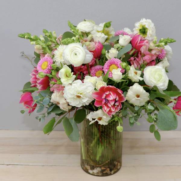 Mixed pink and white flowers arranged in a glass vase
