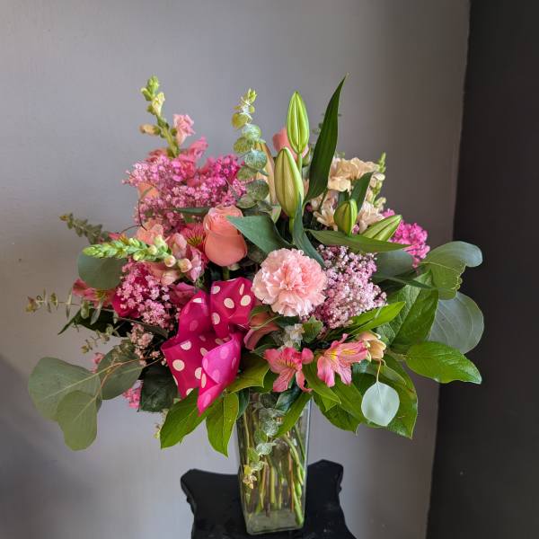 Pink mixed bouquet with lilies, roses, and carnations in a glass vase