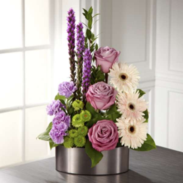 Pink roses and pale gerbera daisies in a silver vase