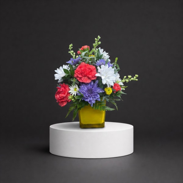 Colorful mixed flower arrangement in a yellow vase