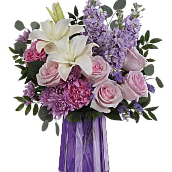 Bouquet of white lilies, pink roses, and purple flowers in a purple vase