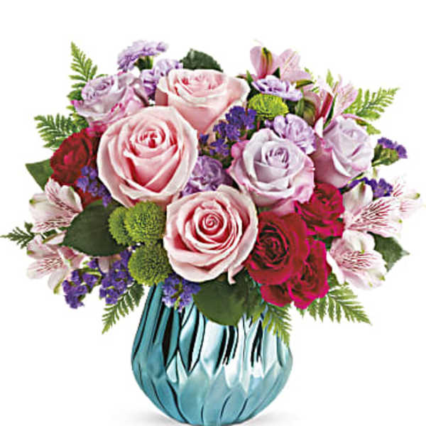 Pink and lavender rose bouquet in a blue glass vase