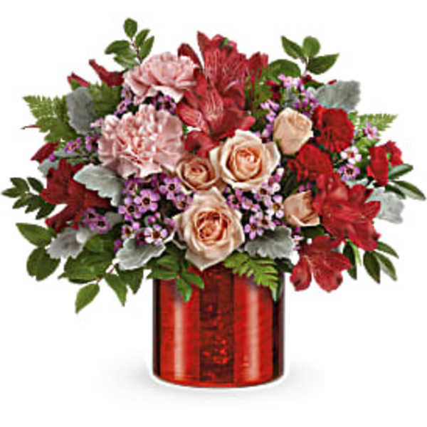Red and blush floral arrangement in a red vase