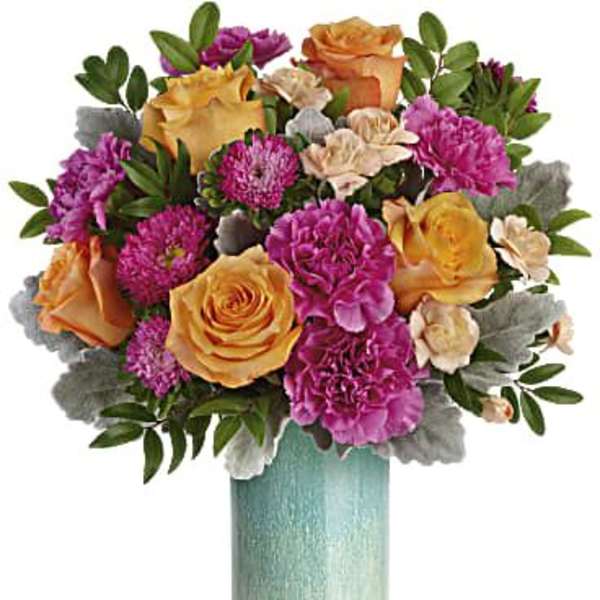 Bouquet of orange and pink flowers in a tall turquoise vase