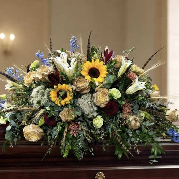 Large casket spray with sunflowers, lilies, and roses