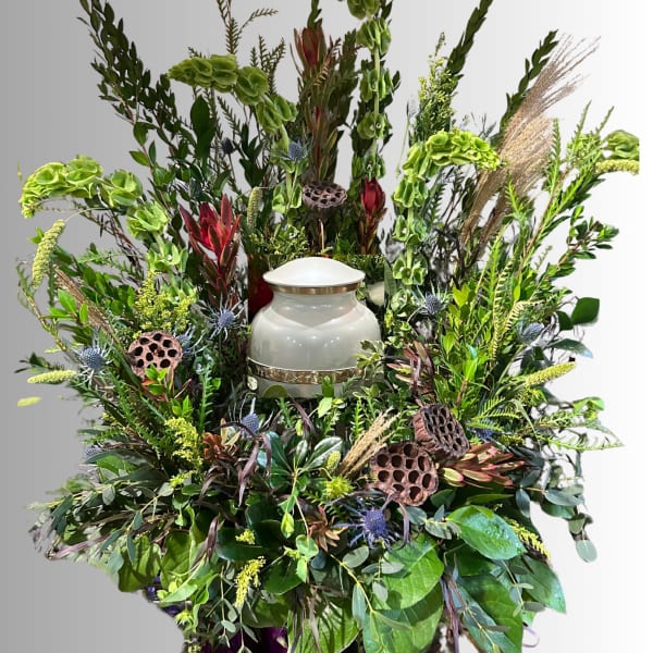 Large floral funeral spray with a white urn in the center