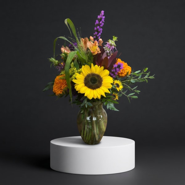 Mixed bouquet with a large sunflower in a glass vase