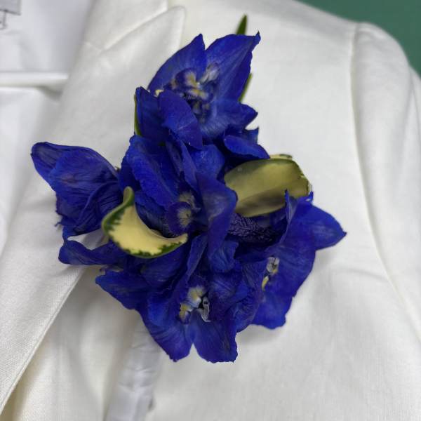 Blue flower boutonniere with white ribbon wrap