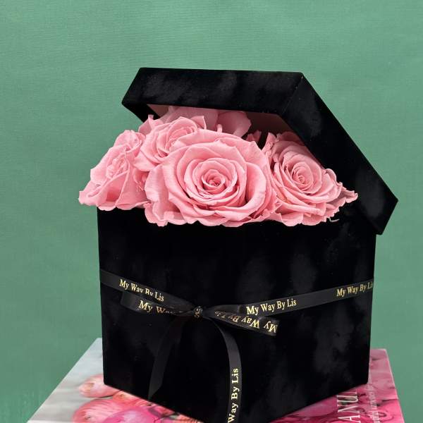 Pink roses in a black box tied with a ribbon