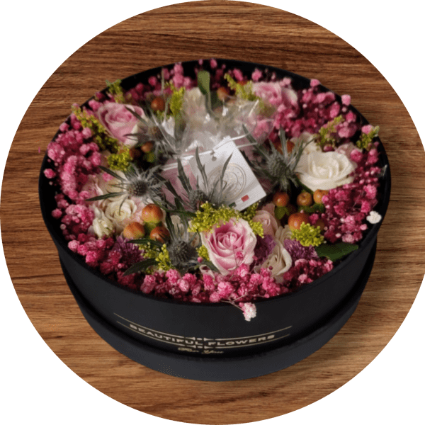 Round box of pink and white roses with small filler flowers