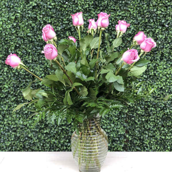 Pink roses arranged in a clear glass vase