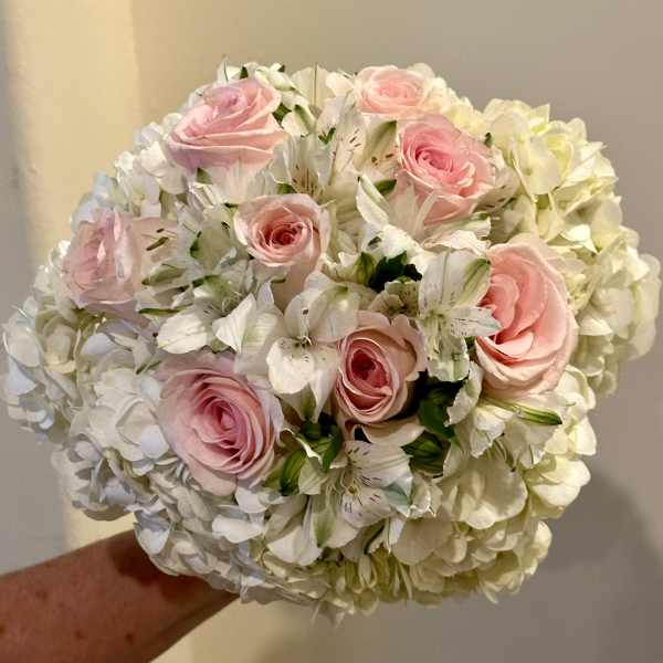 Pink roses and white flowers in a round bouquet